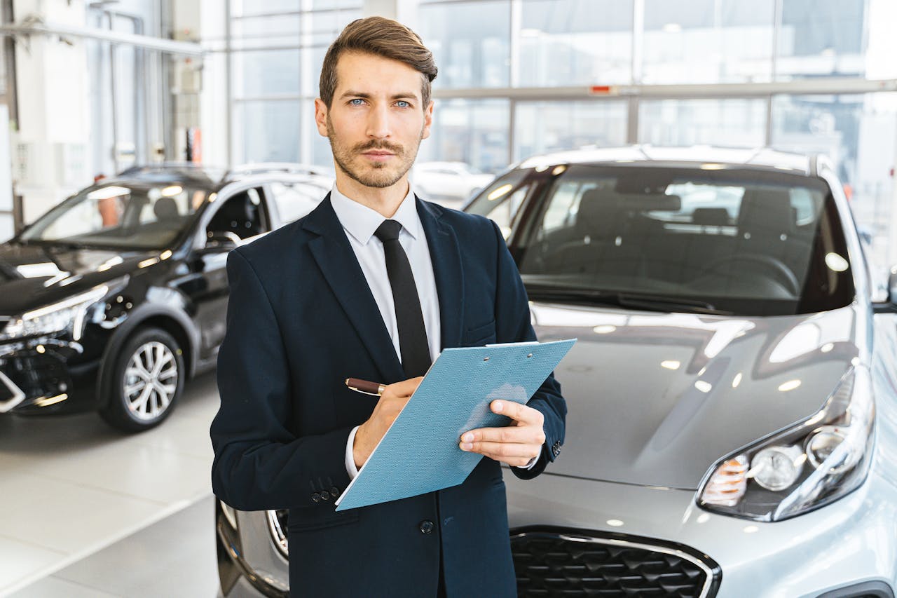 team-04 A confident car salesman in a showroom, holding a clipboard and pen.
